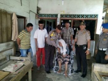 Kapolsek Burem Bayeun Iptu Imran beserta anggotanya saat memberikan bantuan kursi roda. FOTO : ROBY SINAGA