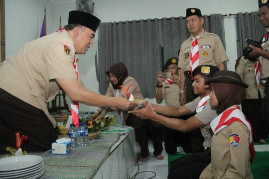 Bupati Jepara Ahmad Marzuki saat menyerahkan tumpeng kepada dua perwakilan Pramuka. FOTO : DSW