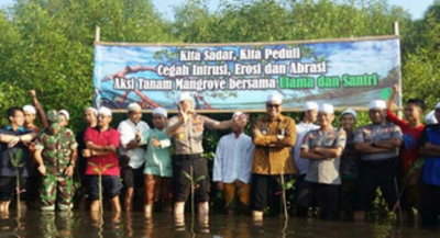 Santri dan jajaran Polresta Probolinggo foto bersama usai melakukan penanaman pohon mangrove. FOTO : ASL